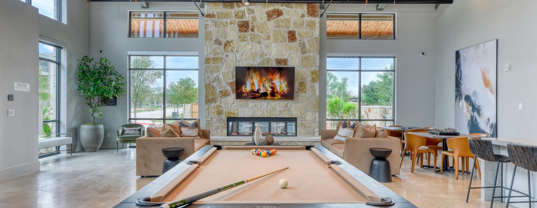 a room with a pool table and chairs and a fireplace
